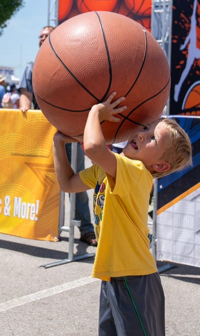 Gideon Moore, 7, shoots one of the giant basketballs Friday, July 28, 2023, at the Indiana State Fair in Indianapolis.