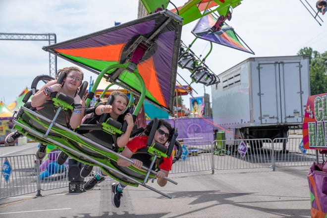 Carly Brake, 15, Eli Briggs, 11 and Isaac Williams, 16, ride cliffhanger Friday, July 28, 2023, at the Indiana State Fair in Indianapolis.